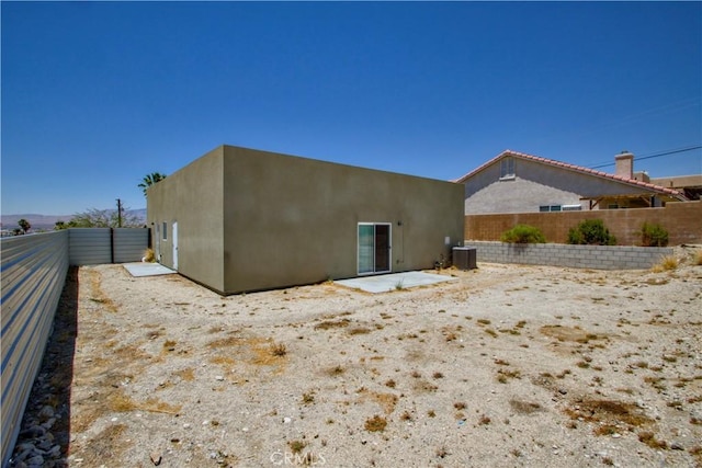 12612 Maui Way, Desert Hot Springs, CA 92240 - back of property with central AC, a fenced backyard, stucco siding, and a patio area