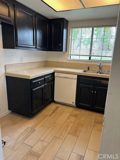 546 Northpoint Cir, Santa Maria, CA 93455 - kitchen with white dishwasher, a sink, dark cabinets, and light wood-style floors