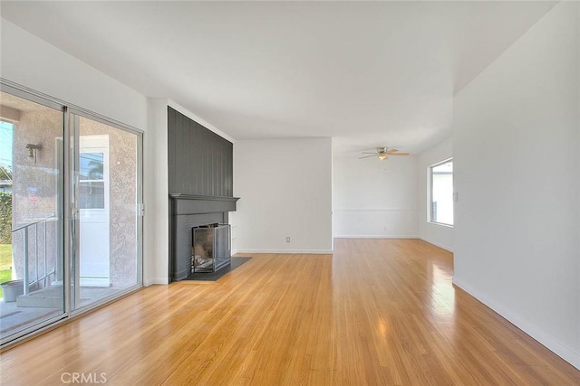 11206 Quinn St, Downey, CA 90241 - unfurnished living room with light wood-style flooring, a fireplace, a ceiling fan, and baseboards
