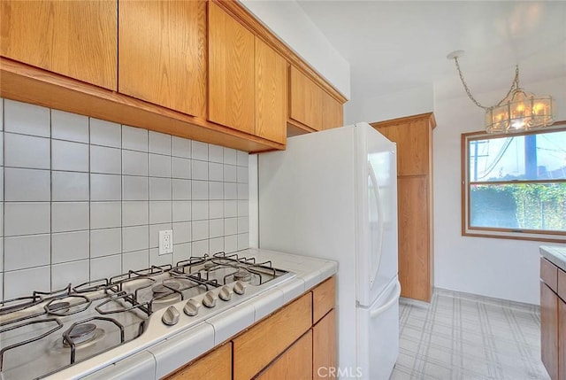 11206 Quinn St, Downey, CA 90241 - kitchen featuring gas stovetop, tile countertops, decorative backsplash, a chandelier, and freestanding refrigerator
