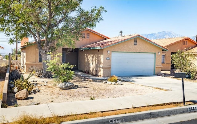 66427 3rd St, Desert Hot Springs, CA 92240 - view of front facade featuring an attached garage, driveway, stucco siding, and a mountain view