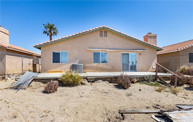 66427 3rd St, Desert Hot Springs, CA 92240 - back of house featuring stucco siding, cooling unit, a chimney, and a tile roof