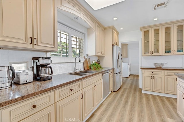 4901 Ethel Ave, Sherman Oaks, CA 91423 - kitchen with a sink, independent washer and dryer, cream cabinets, stainless steel appliances, and backsplash