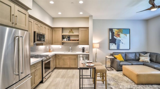 876 Doheny Way, Dana Point, CA 92629 - kitchen featuring appliances with stainless steel finishes, a sink, light countertops, light wood finished floors, and decorative backsplash