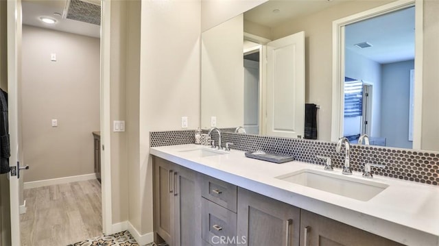 876 Doheny Way, Dana Point, CA 92629 - full bathroom with double vanity, decorative backsplash, baseboards, and wood finished floors