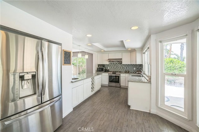6114 Sard St, Rancho Cucamonga, CA 91701 - kitchen featuring stainless steel appliances, under cabinet range hood, backsplash, white cabinets, and a textured ceiling