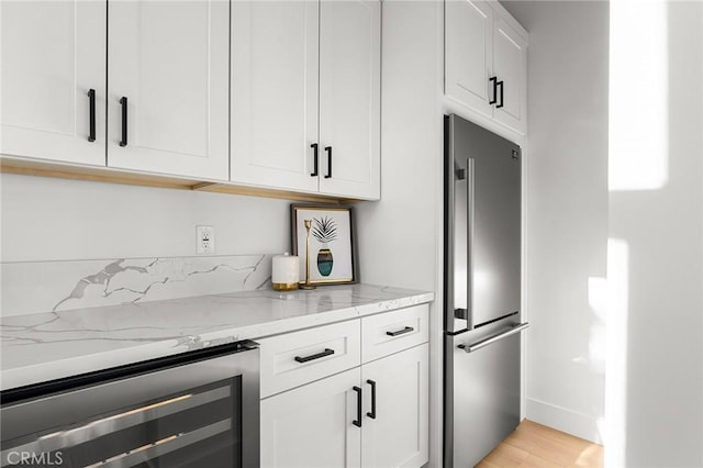 4956 Malibu Dr, Paradise, CA 95969 - kitchen featuring stainless steel fridge, beverage cooler, light stone counters, and white cabinets
