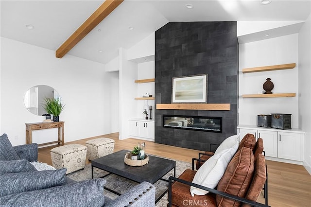 4956 Malibu Dr, Paradise, CA 95969 - living area with vaulted ceiling, light wood finished floors, a fireplace, built in shelves, and recessed lighting