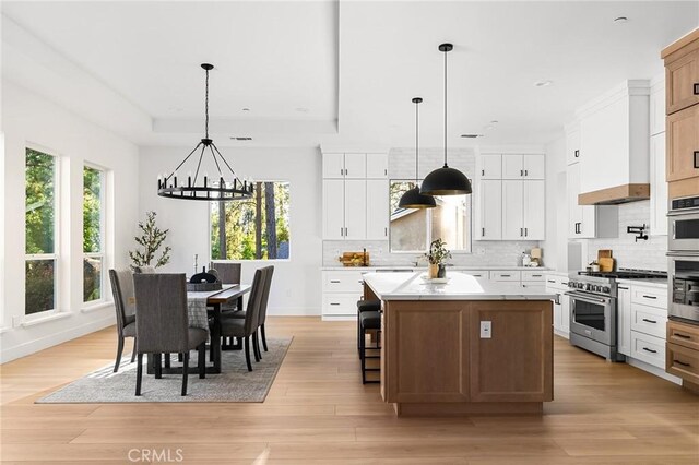 4956 Malibu Dr, Paradise, CA 95969 - kitchen featuring appliances with stainless steel finishes, a center island, a chandelier, light countertops, and backsplash