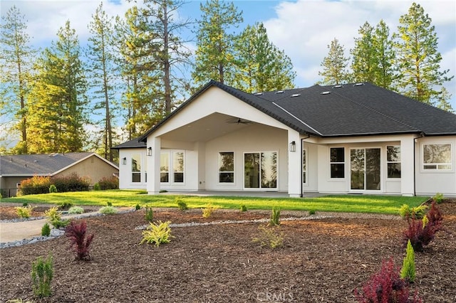 4956 Malibu Dr, Paradise, CA 95969 - back of property featuring a ceiling fan, stucco siding, a lawn, a patio area, and a shingled roof