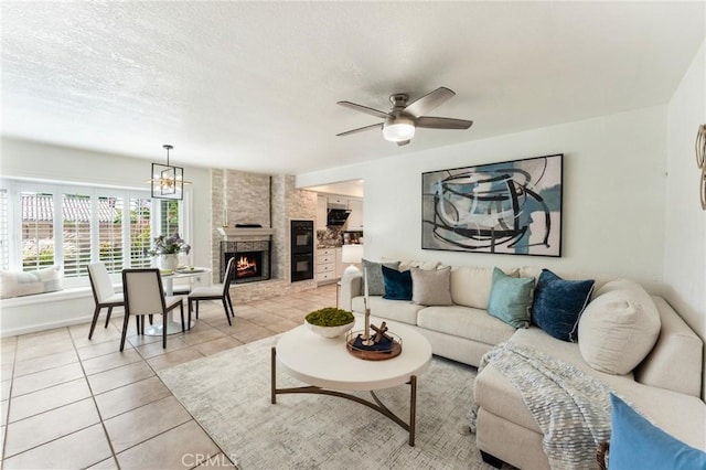 5291 Strasbourg Ave, Irvine, CA 92604 - living room with light tile patterned floors, a fireplace, ceiling fan, a chandelier, and a textured ceiling