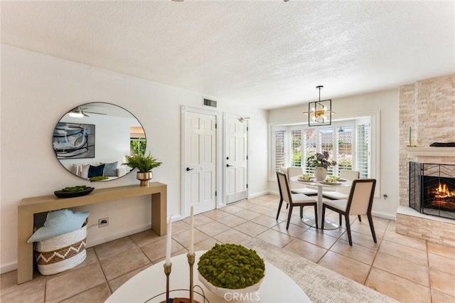5291 Strasbourg Ave, Irvine, CA 92604 - tiled dining space with a textured ceiling, a fireplace, and baseboards