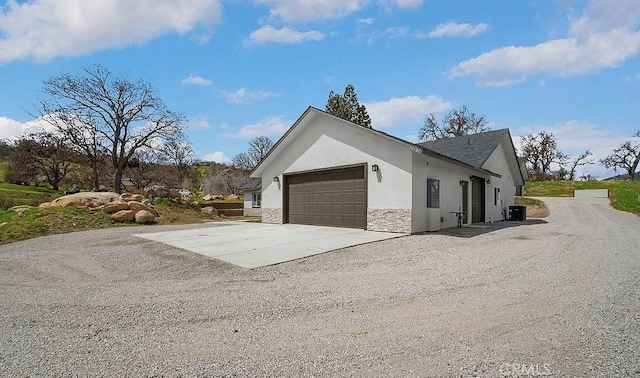 30181 Knight Ct, Tehachapi, CA 93561 - view of side of property featuring stucco siding, driveway, an attached garage, and stone siding