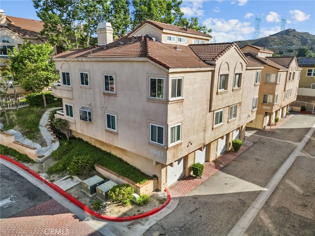 19852 Sandpiper Pl Unit 96, Newhall, CA 91321 - view of building exterior with a garage, driveway, and a mountain view