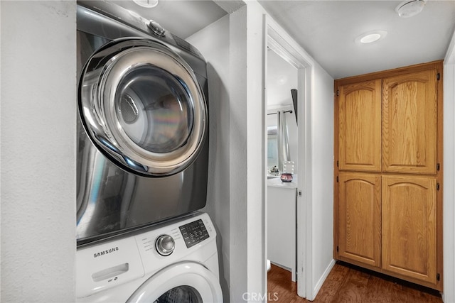 19852 Sandpiper Pl Unit 96, Newhall, CA 91321 - laundry area featuring stacked washer / drying machine, dark wood-type flooring, and cabinet space