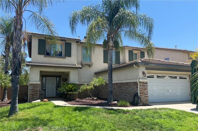 30710 Tierra Linda Ct, Menifee, CA 92584 - view of front of property with stucco siding, a front yard, brick siding, and driveway