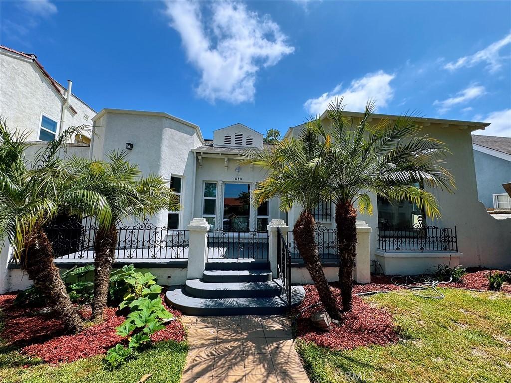 1040 W 64th St, Los Angeles, CA 90044 - mediterranean / spanish-style home with stucco siding and a wooden deck