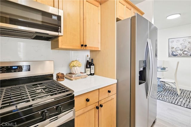 4429 Tremont St Unit 4, San Diego, CA 92102 - kitchen featuring appliances with stainless steel finishes, light brown cabinetry, light countertops, and light wood finished floors