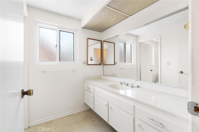 8754 Prichard St, Downey, CA 90242 - bathroom with vanity, baseboards, and speckle patterned floor
