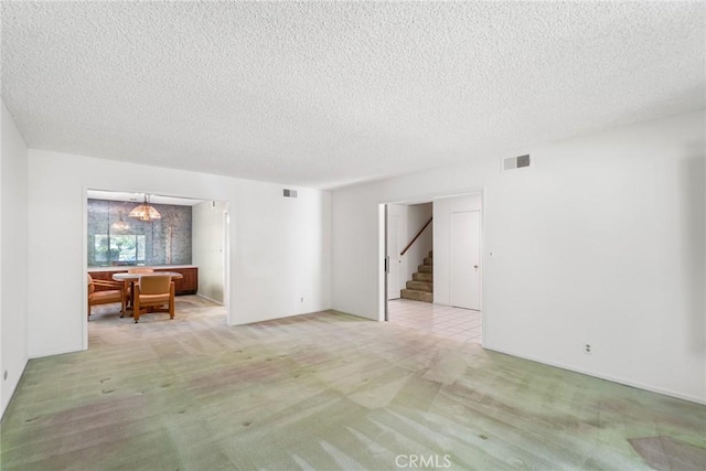 8754 Prichard St, Downey, CA 90242 - spare room with stairs, a textured ceiling, and light carpet
