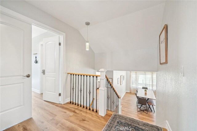 7906 Appaloosa Ct, Rancho Cucamonga, CA 91701 - corridor featuring an upstairs landing, vaulted ceiling, wood finished floors, and baseboards