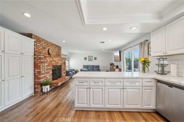 7906 Appaloosa Ct, Rancho Cucamonga, CA 91701 - kitchen featuring stainless steel dishwasher, a peninsula, white cabinetry, recessed lighting, and a brick fireplace