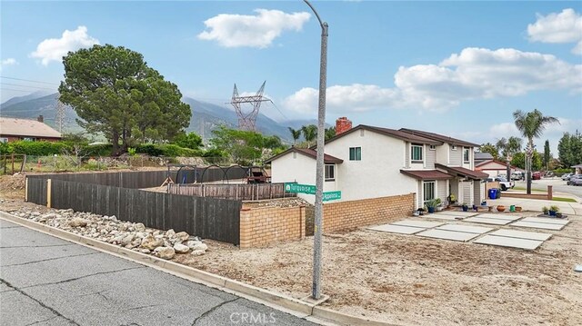 7906 Appaloosa Ct, Rancho Cucamonga, CA 91701 - view of side of property featuring a mountain view, stucco siding, and a chimney