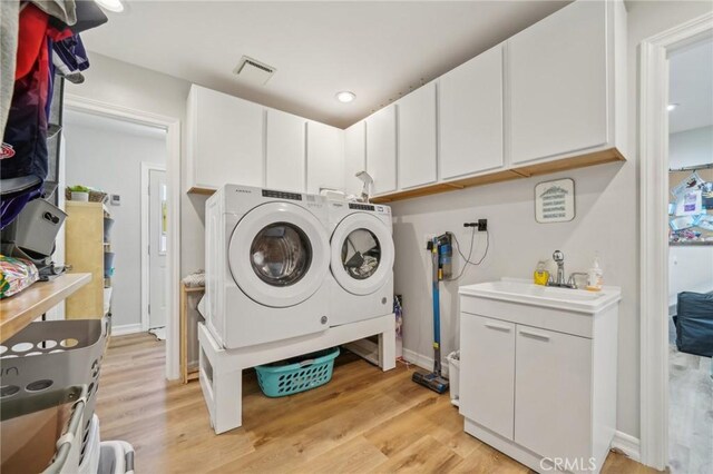 7906 Appaloosa Ct, Rancho Cucamonga, CA 91701 - washroom featuring independent washer and dryer, a sink, and light wood finished floors