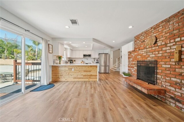 7906 Appaloosa Ct, Rancho Cucamonga, CA 91701 - unfurnished living room with light wood finished floors, recessed lighting, and a brick fireplace