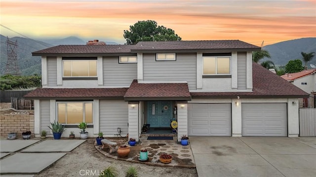 7906 Appaloosa Ct, Rancho Cucamonga, CA 91701 - view of front of house with driveway, a shingled roof, a mountain view, an attached garage, and a chimney