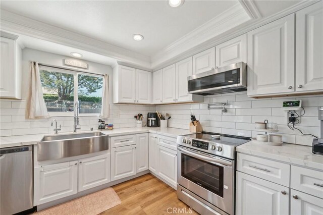 7906 Appaloosa Ct, Rancho Cucamonga, CA 91701 - kitchen with appliances with stainless steel finishes, a sink, white cabinetry, backsplash, and recessed lighting