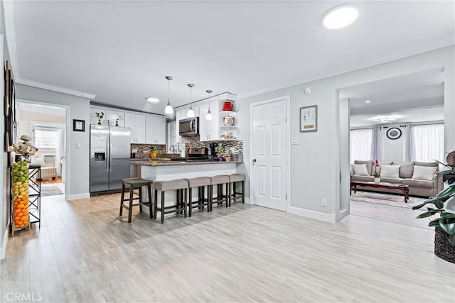 20402 Pioneer Blvd, Lakewood, CA 90715 - kitchen with appliances with stainless steel finishes, a peninsula, open floor plan, a breakfast bar, and tasteful backsplash