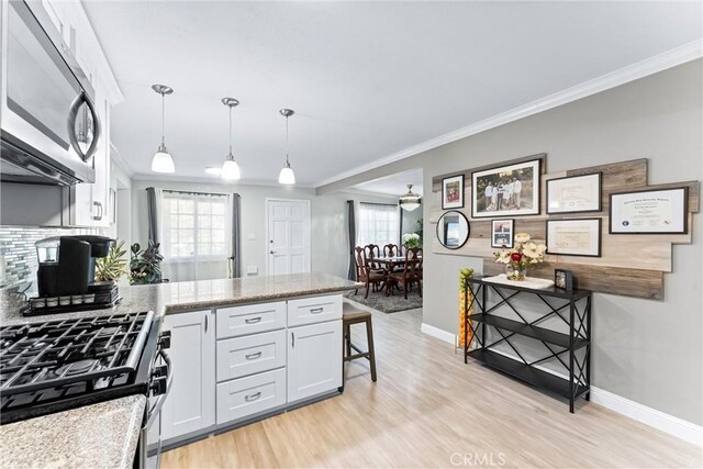 20402 Pioneer Blvd, Lakewood, CA 90715 - kitchen with stainless steel appliances, a peninsula, crown molding, baseboards, and light wood finished floors