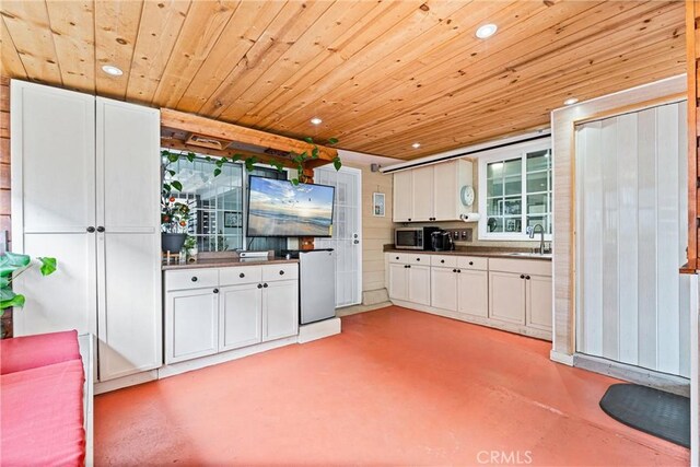 20402 Pioneer Blvd, Lakewood, CA 90715 - kitchen featuring a sink, finished concrete flooring, wood ceiling, stainless steel microwave, and white cabinets