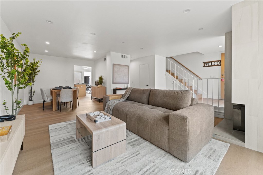17878 La Lima St, Fountain Valley, CA 92708 - living area featuring light wood-style flooring, stairs, recessed lighting, and a glass covered fireplace