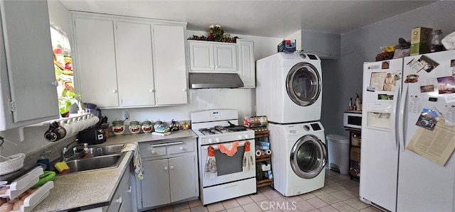 450 W D St, Colton, CA 92324 - kitchen with white appliances, stacked washer / drying machine, under cabinet range hood, a sink, and light countertops