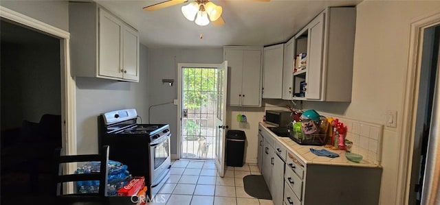 450 W D St, Colton, CA 92324 - kitchen with gas range, a ceiling fan, light countertops, light tile patterned flooring, and white cabinetry