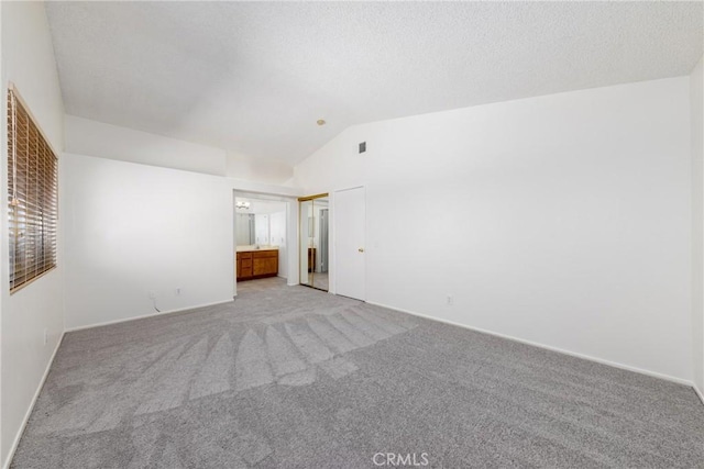 4231 Sage Ct, Palmdale, CA 93552 - unfurnished room featuring light carpet, lofted ceiling, baseboards, and a textured ceiling