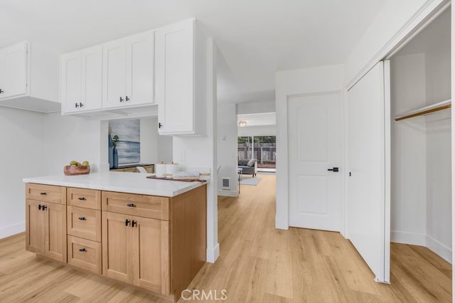 676 N 12th St Unit 21, Grover Beach, CA 93433 - kitchen with light wood-type flooring, light countertops, baseboards, and white cabinets