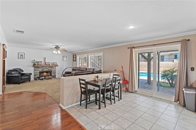 38701 Annette Ave, Palmdale, CA 93551 - dining area with ornamental molding, ceiling fan, healthy amount of natural light, a fireplace, and a textured ceiling