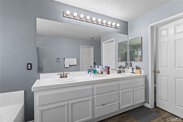 38701 Annette Ave, Palmdale, CA 93551 - full bath with a textured wall, double vanity, wood finished floors, a textured ceiling, and a tub