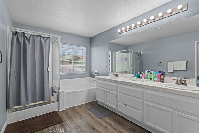 38701 Annette Ave, Palmdale, CA 93551 - bathroom with a shower stall, wood finished floors, double vanity, a textured ceiling, and a garden tub