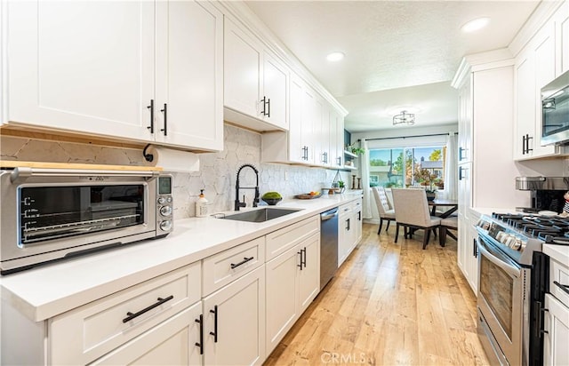 7017 Filkins Ave, Rancho Cucamonga, CA 91701 - kitchen with stainless steel appliances, a sink, white cabinetry, backsplash, and recessed lighting