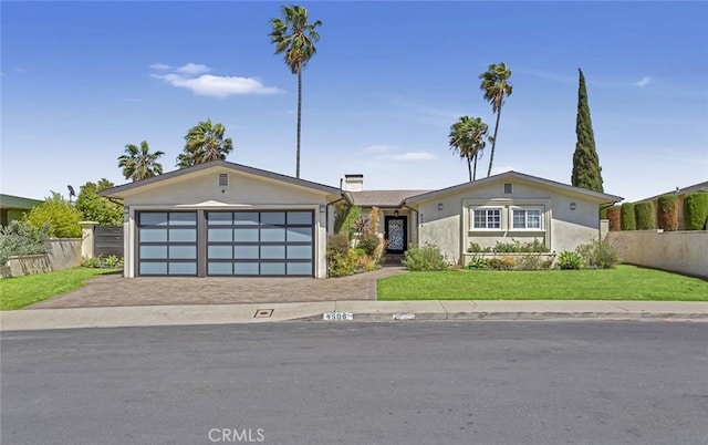 4508 Don Timoteo Dr, Los Angeles, CA 90008 - mid-century modern home with decorative driveway, an attached garage, stucco siding, and a chimney