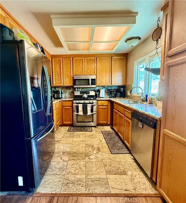 9307 Banderilla Dr, La Grange, CA 95329 - kitchen with stainless steel appliances, a sink, brown cabinets, and tasteful backsplash