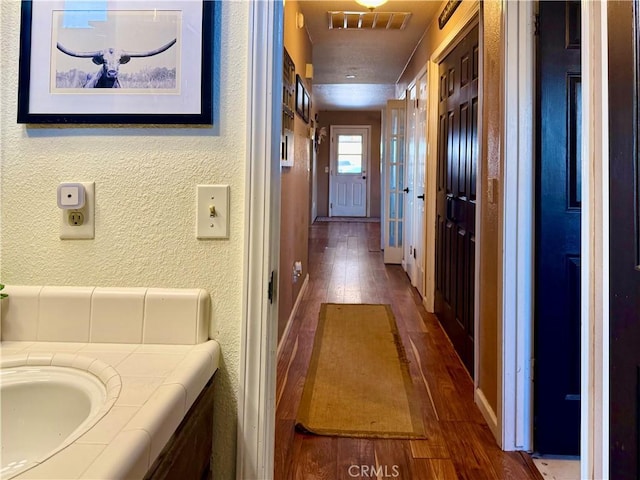 9307 Banderilla Dr, La Grange, CA 95329 - corridor featuring hardwood / wood-style floors, a textured wall, and baseboards