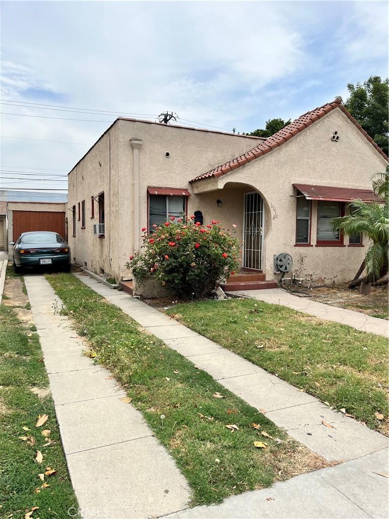 6010 Linden Ave, Long Beach, CA 90805 - view of front of house with stucco siding, a front yard, and a tile roof