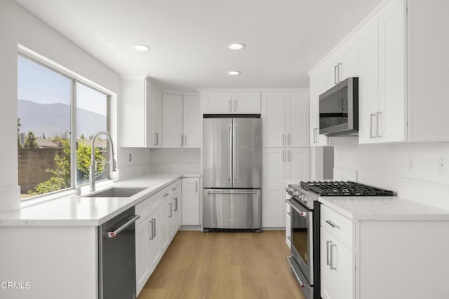 196 Mariposa Dr, Camarillo, CA 93012 - kitchen featuring appliances with stainless steel finishes, a sink, recessed lighting, white cabinets, and light countertops