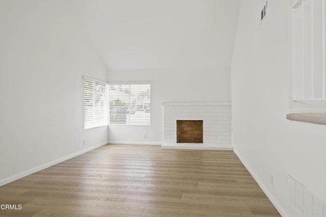 196 Mariposa Dr, Camarillo, CA 93012 - unfurnished living room with wood finished floors, vaulted ceiling, a brick fireplace, and baseboards
