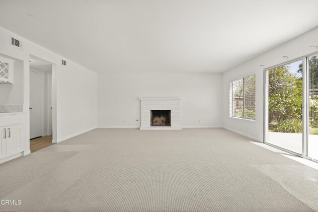 196 Mariposa Dr, Camarillo, CA 93012 - unfurnished living room with light carpet, baseboards, and a brick fireplace